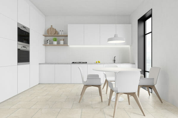 Corner of stylish kitchen with white and gray walls, concrete floor, comfortable grey countertops with built in ovens, wooden shelves and round dining table with chairs. 3d rendering